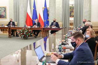 Uczestnicy spotkania siedzą w sali kolumnowej
